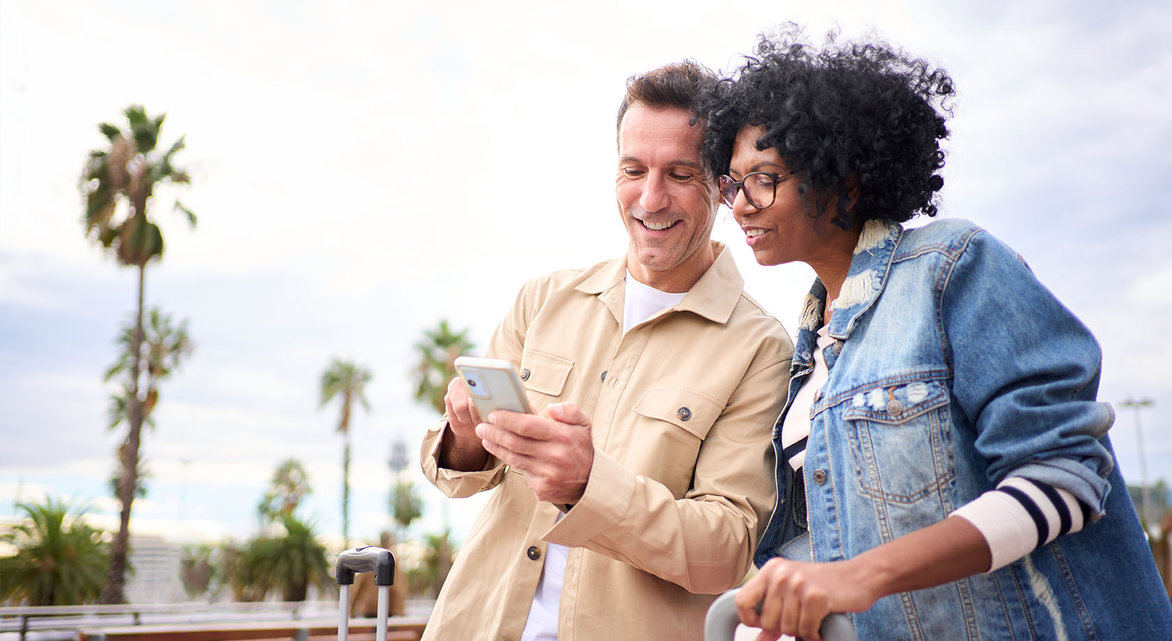 Man and women looking excitedly at a mobile phone.